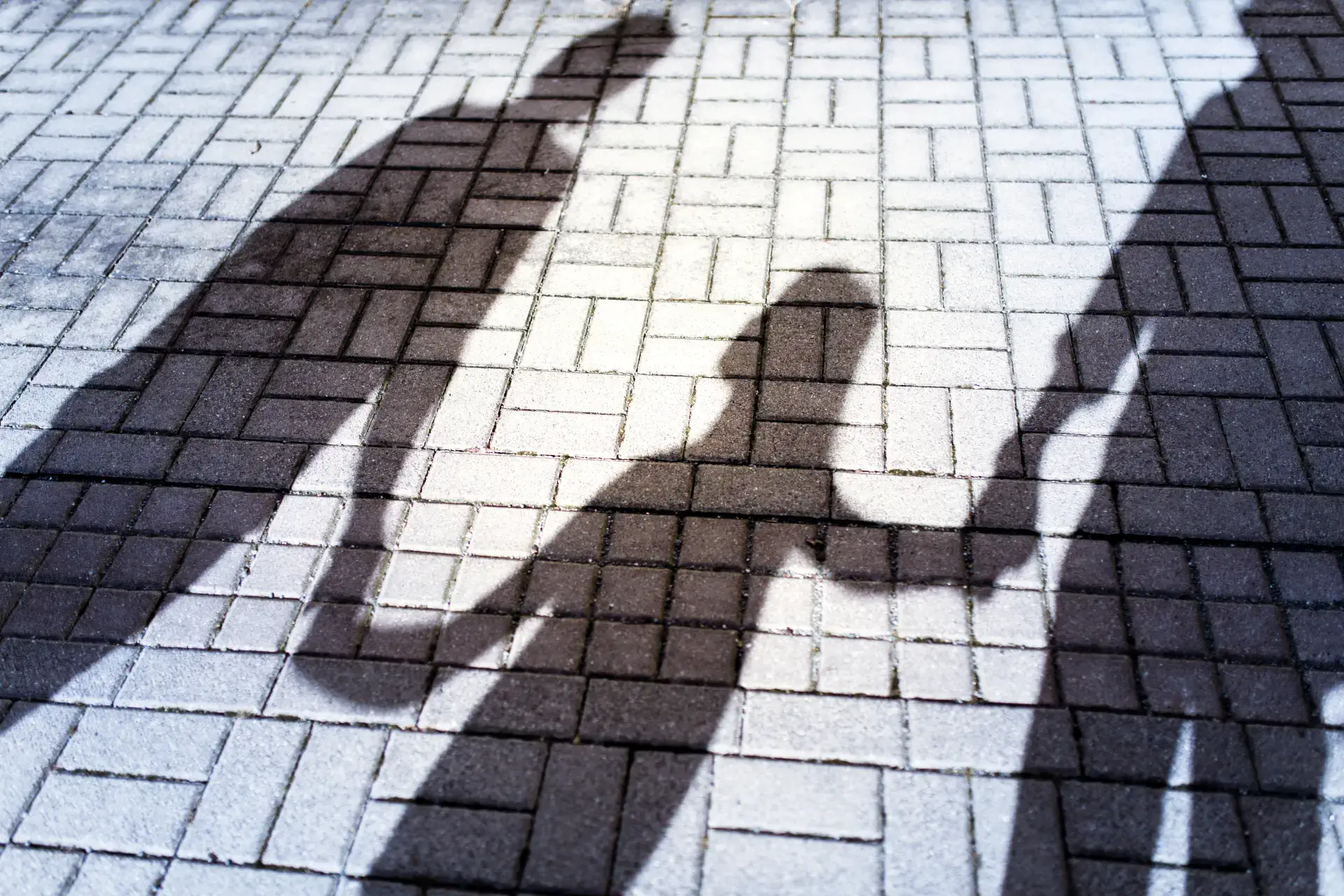 Shadow of separated parents with a child between them during divorce.