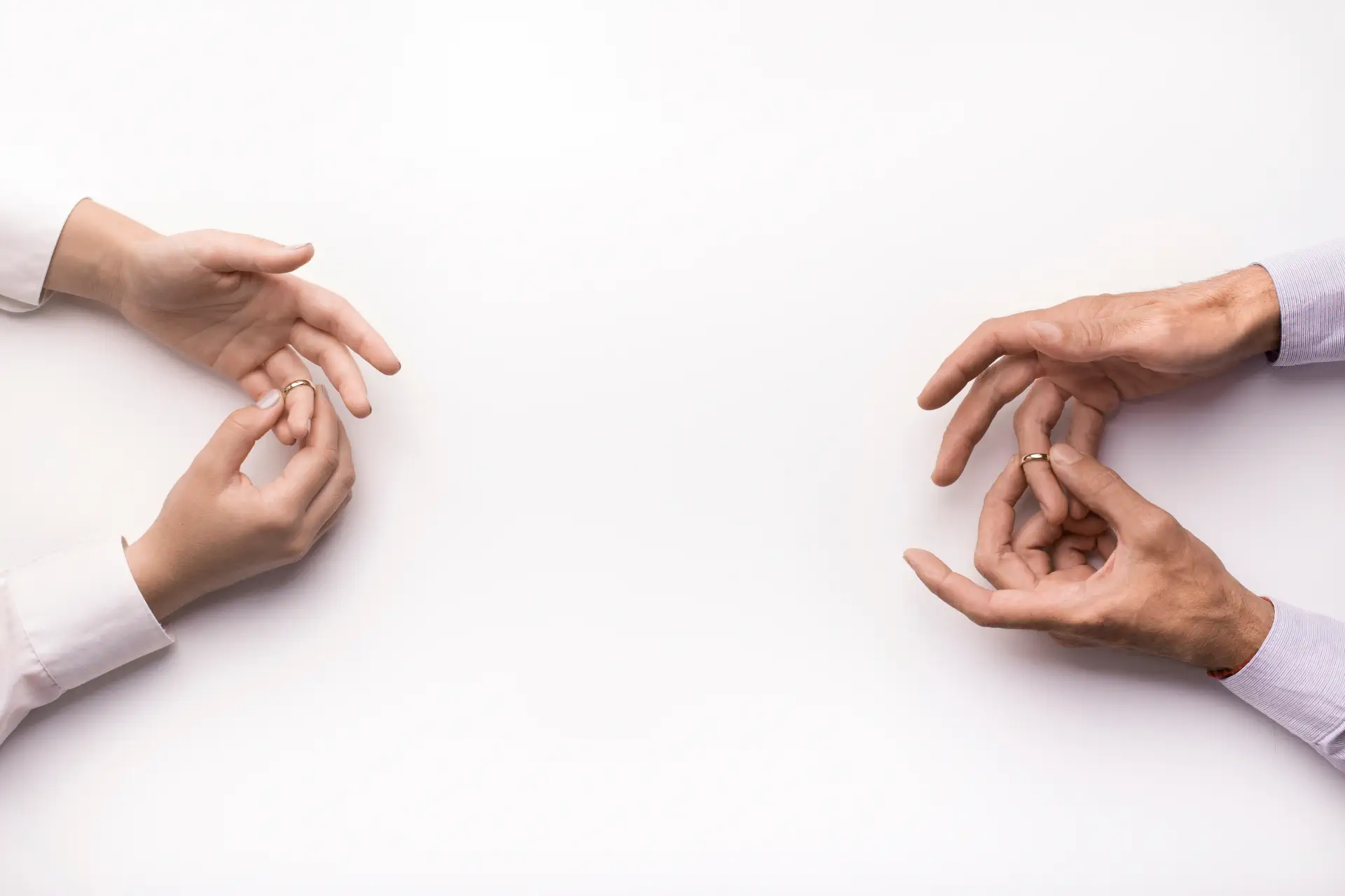 Couple sitting apart, removing their wedding rings during an early divorce process in Singapore.