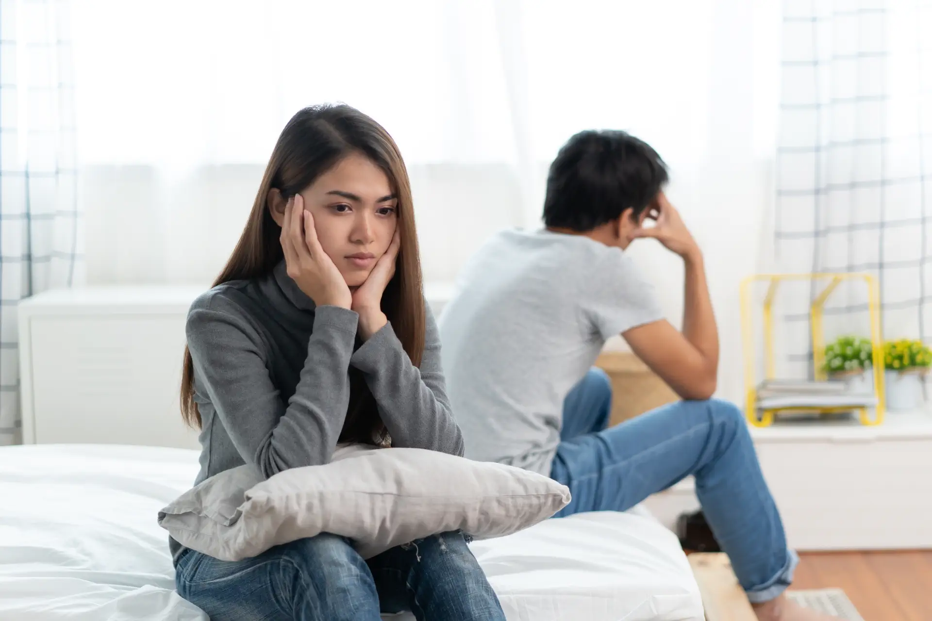 Married couple appearing distressed and distant, reflecting divorce considerations before 3 years of marriage in Singapore.