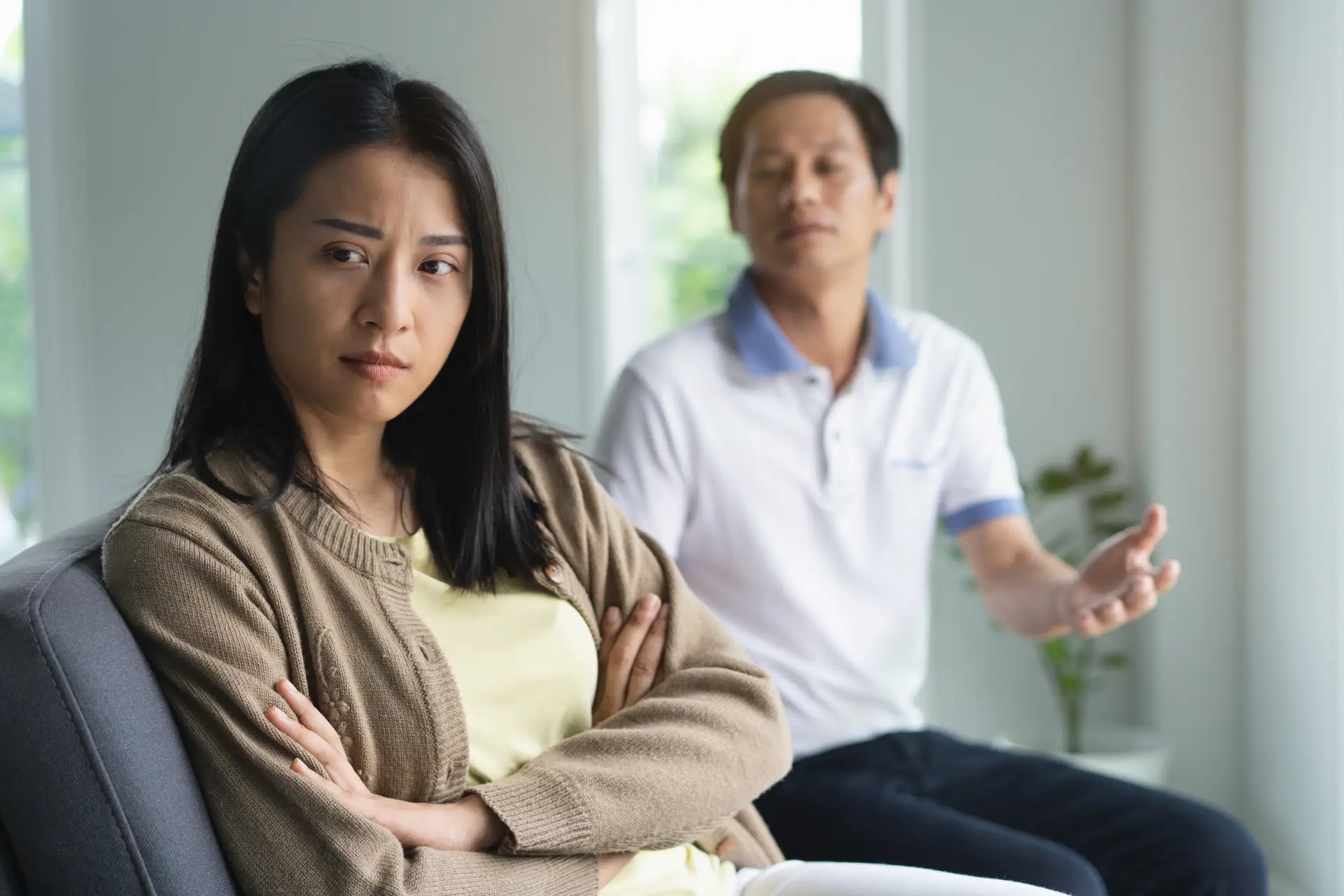 Woman frowning with a man behind her, reflecting early marital conflict that causes divorce within 1 year of marriage.