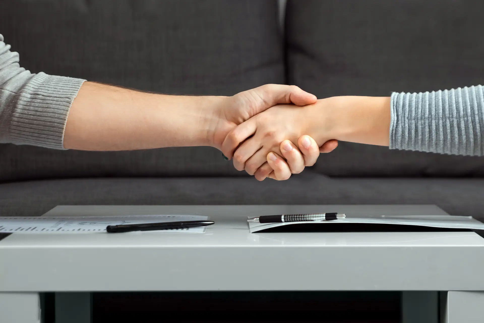 Couple shaking hands over divorce papers during a fast, uncontested divorce in Singapore.